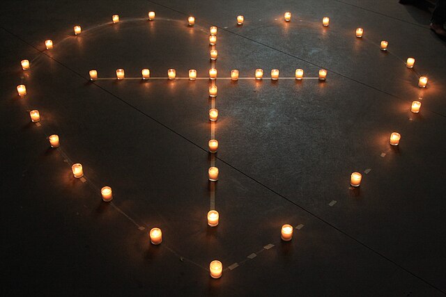 A cross in a heart formed with candles. Photos taken in Camp Tejas, Giddings, Texas, USA. Wingchi Poon.